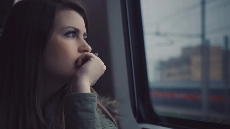 When we pray to God for forgiveness we must commit to doing our part in turning away from our sinful behavior, and toward Him. A woman looking out of a window on a commuter train.