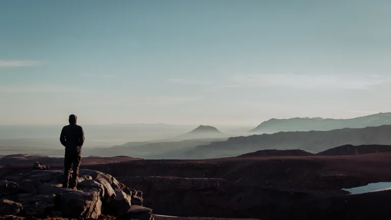 Many people have given up on life and committed suicide. Their hope is lost but for a moment while they rest in the grave. Although they failed in this life, God will not fail in His mercy. A young man standing on top of a cliff.