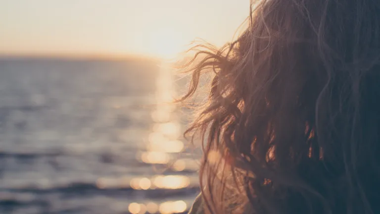 It’s only when we push God’s hands away, when we try to go it alone and do it our way, that we fall flat and hurt ourselves in the process. A young woman looking out over the ocean.