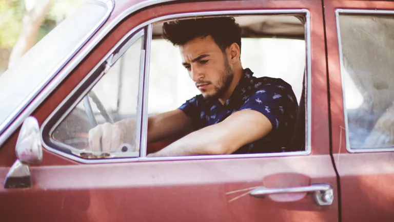 Sorrow has its place, but we must not allow it to dictate our lives. We have to learn to live with it, but to live strongly. A young man sitting in the driver's seat of an old car.