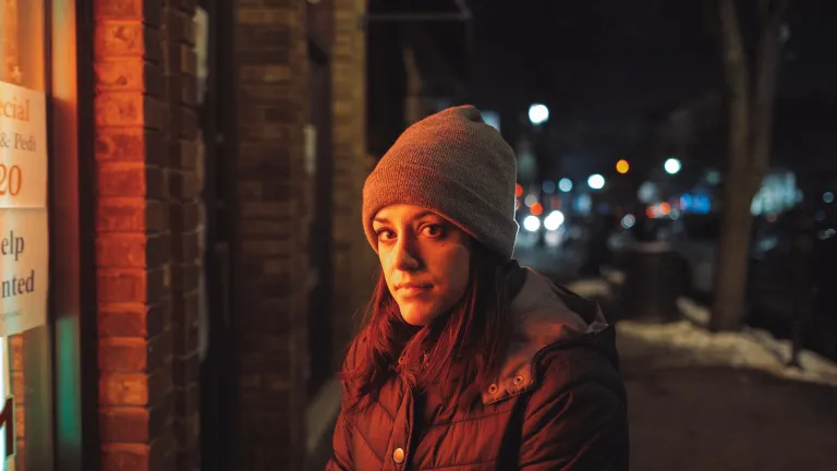 A young woman standing outside a store.
