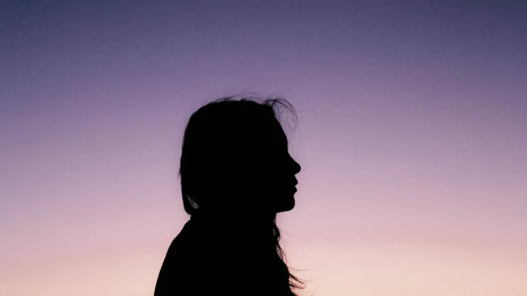 The reason bad things happen to good people is that our world continually reaps the results of sin. Mankind has forsaken God, and we are paying the consequences. A silhouette of young woman with the sun setting in the background.