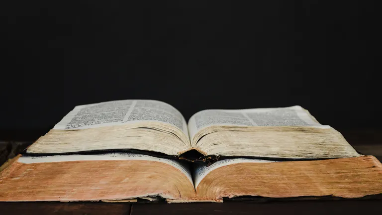 Bible prophecy tracks the progression of world empires even to modern times and beyond. Two open Bible stacked on top of each other.
