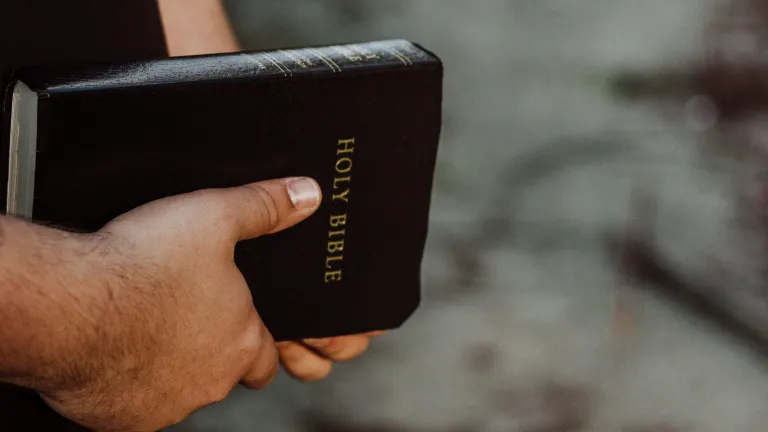 You do not find in the Bible where it says the injured party was to inflict these injuries on the offender. A man holding a Bible.