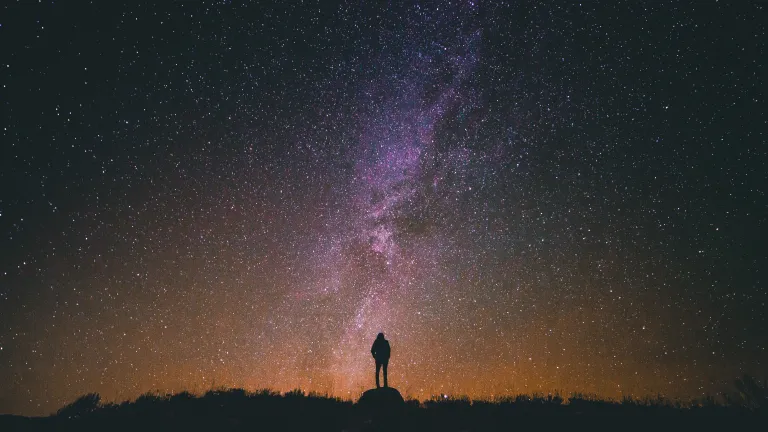 By the Spirit we are literal heirs of God and joint heirs with Christ. We are part of the God family. God is preparing us to inherit all things. A person standing at night with stars in the background.