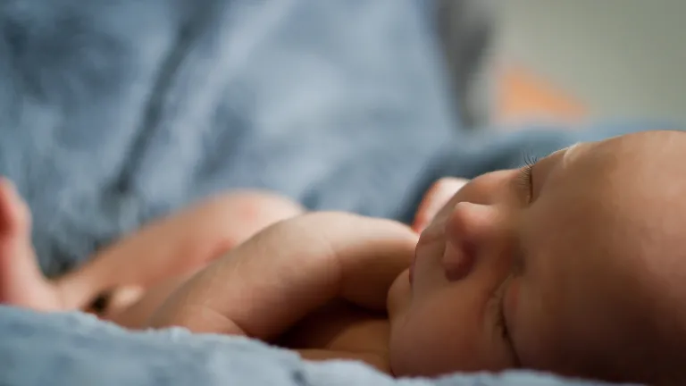 New born baby lying on a blanket.