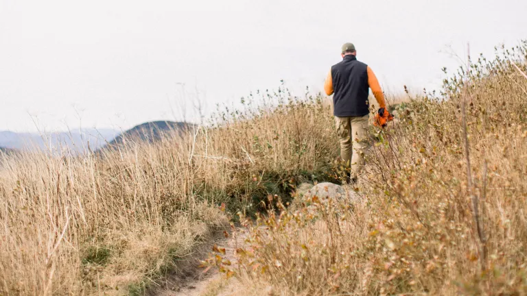 A man walking on a dirt trail.