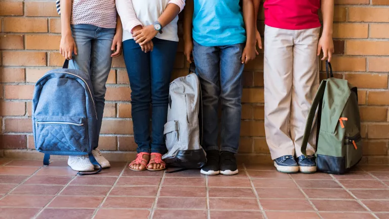 It’s terribly sad that the darkening world around us has brought us to this quandary. Kids holding backpacks.