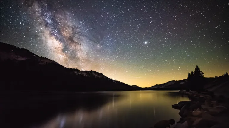Starry night over lake with Milkyway galaxy.