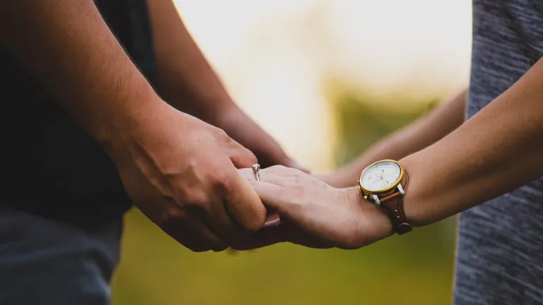 Our all-loving and all-wise Creator gave us the Seventh Commandment to exalt and protect the precious relationship of marriage! Photo of man and woman with wedding rings holding hands.