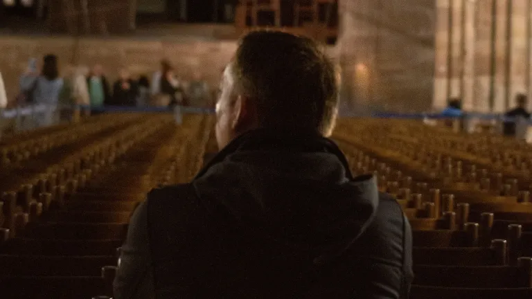 Christians who practice making the sign of the cross believe it is an acknowledgment of God’s presence, favor and protection. A man sitting in a church.