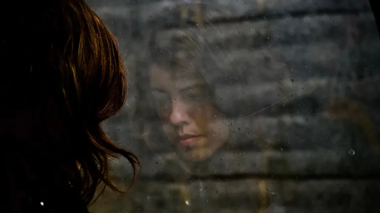 Spend more of your valuable time thinking about God's plan for you and His plan for the future. Don't waste time fretting about things you cannot really control anyway. The reflection of a woman in a window.