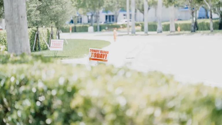Photo of a sign, pointing to a donation center, saying "Donate Blood Today."