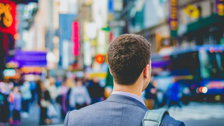 Let our daily duty be complete with that which builds toward eternity. Be rich toward God before worrying about being rich for yourself. A business man walking in a busy city.