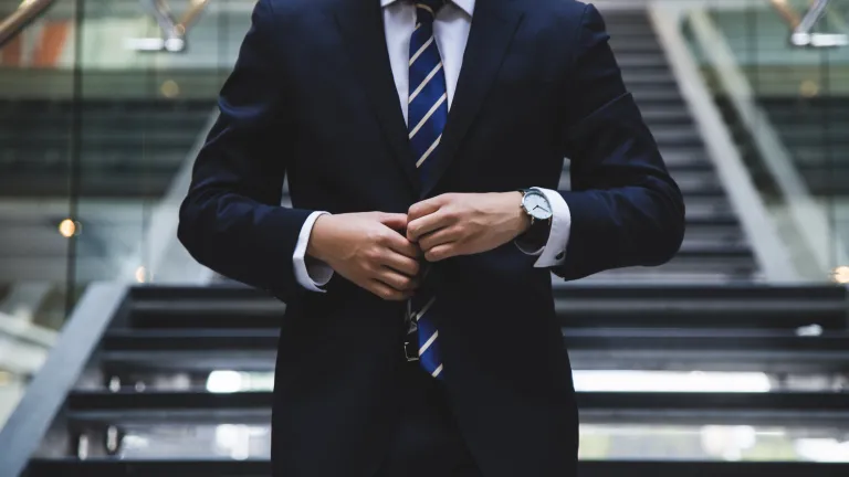 Genuine character development cannot occur by merely altering a person’s outward actions and appearance. Lasting change must begin on the inside and then be reflected on the outside. Photo of a man buttoning a tailored suit.