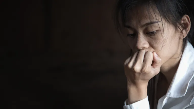 A woman with her chin resting on her hand.