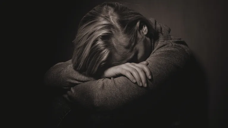 Whatever trial you’re going through, it cannot separate you from the love of God. He understands! Jesus Christ knows what it’s like to be human. He loves us. A woman with her head down on her arms.