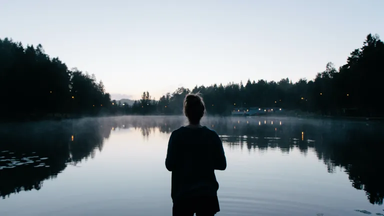 A woman looking at a lake.
