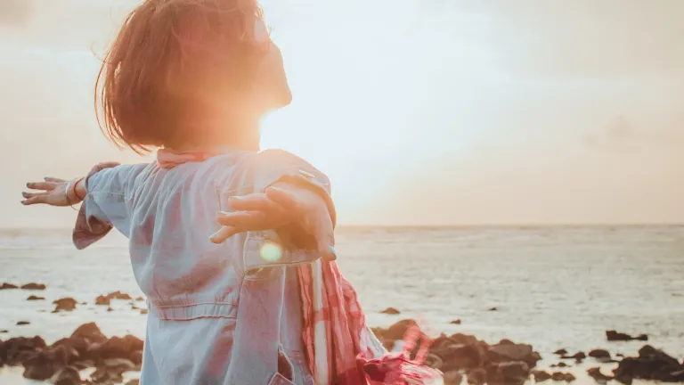 5 Keys to Good Mental Health a happy woman against a bright sunny sky