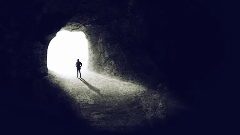 What Should I Do When I'm Afraid? A man in a dark cave looking out from the entrance