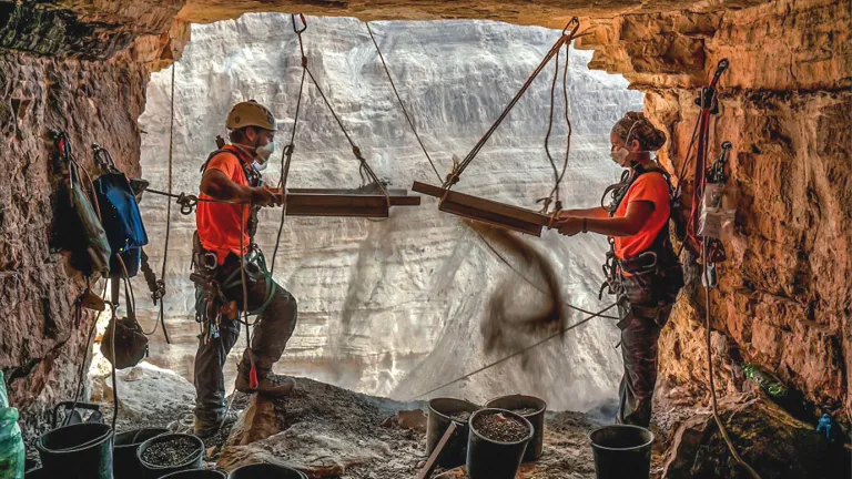 Israeli archeologists Hagay Hamer and Oriah Amichai sift dirt at a cave in the Judean Desert where addtional ancient scroll fragments were found.