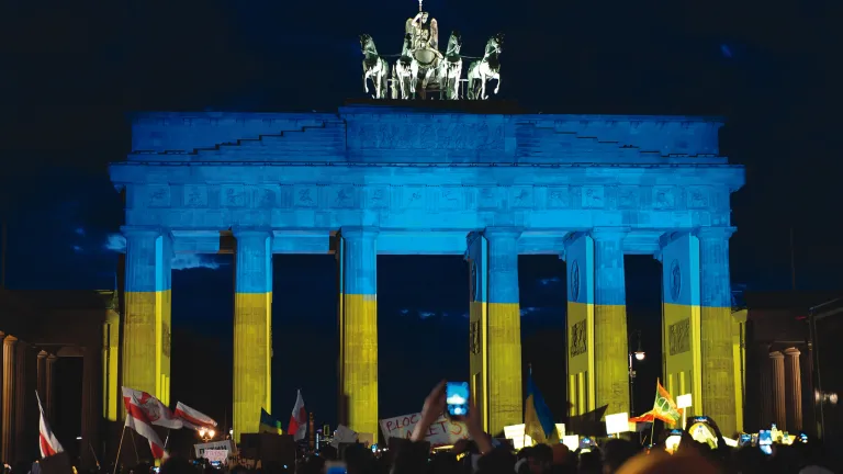 German protestors demonstrate in solidarity with Ukraine in front of the famous Brandenberg gate in Berlin, which is bathed in the colors of the Ukrainian flag.