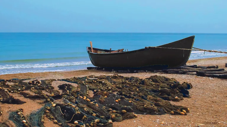 A boat on a sandy shore with nets.
