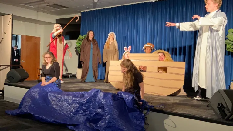The charity auction raised funds to purchase a bus for brethren in Zambia. Students performing a Bible skit