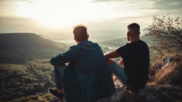 Two people sitting outdoors looking over a landscape