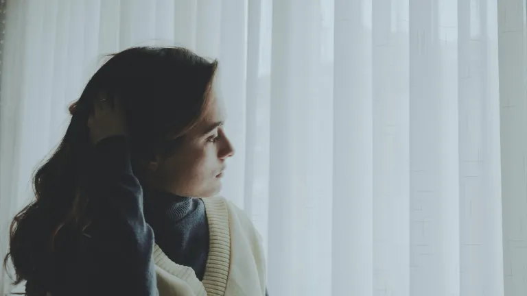 Fear becomes destructive when we obsess and worry continually about what might happen, and allow fear to rule or dominate our lives. This is the kind of fear the Bible warns against. A woman looking curtains outside.