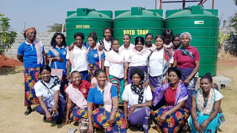 A group of women outdoors wearing an assortment of handmade scarves and coordinating clothing.