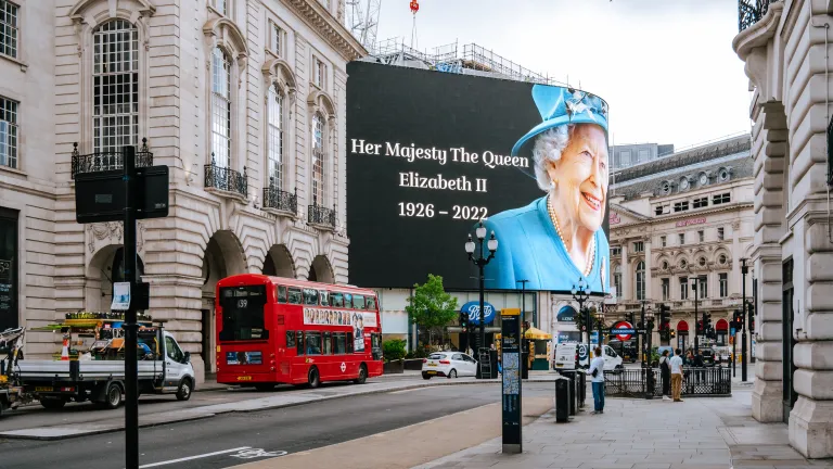 The death of Queen Elizabeth II is a significant event for us to understand within world politics. An electronic billboard stating "Her Majesty The Crown - Elizabeth II - 1926-2022