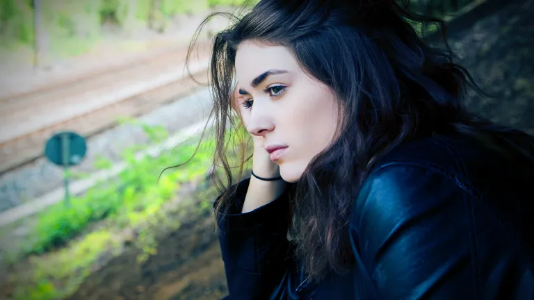 A woman looks pensively over a landscape