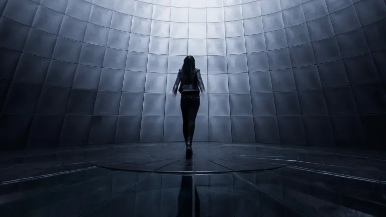 Futurist thinkers envisage the day when people will be able to separate their minds from their biological bodies, and transfer them to a super computer or mega server, and “live” forever in a virtual reality environment. A woman surround by screens.