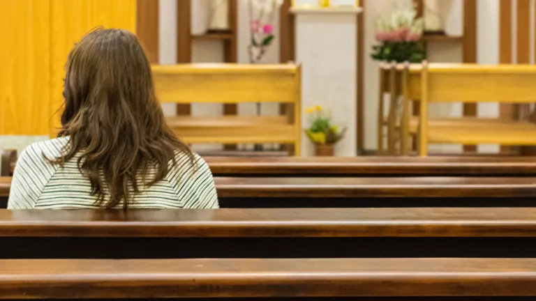 Easter and its customs originated not from the Bible, but in pagan fertility rites. It is a curious mixture of ancient mythological practices and arbitrary dating that obscures and discredits the proof of Jesus Christ’s messiahship and resurrection. A woman sitting in a church.
