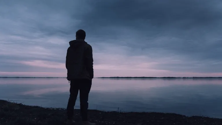 When is the last time you opened your Bible and your heart and let God directly speak to you? Just be honest, brutally honest at that, because honesty is where any movement towards God begins. A silhouette of a man standing by a lake.