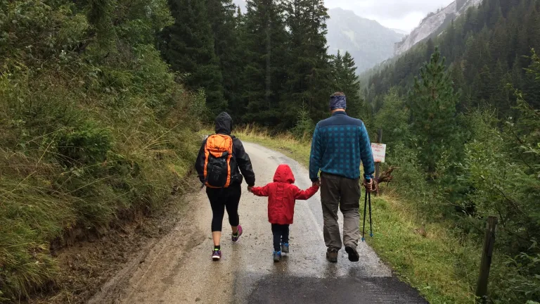We can't afford to let our family relationships slip away. a family of three walking on a road in the mountains