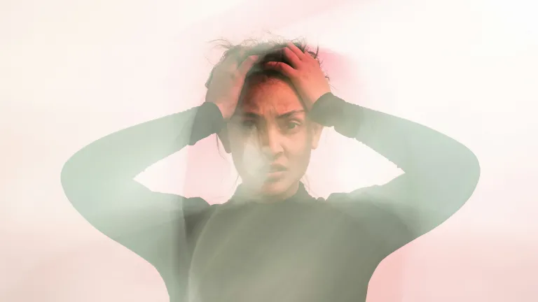 We learn that we must not only banish and defeat negative patterns of thinking and speaking, but also replace those thoughts with something positive and godly. a frowning woman holding her head with both hands