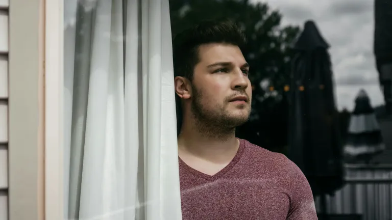 We wrestle with God because we do not always understand His actions and purpose in what He allows. a man looking out a window into the distance