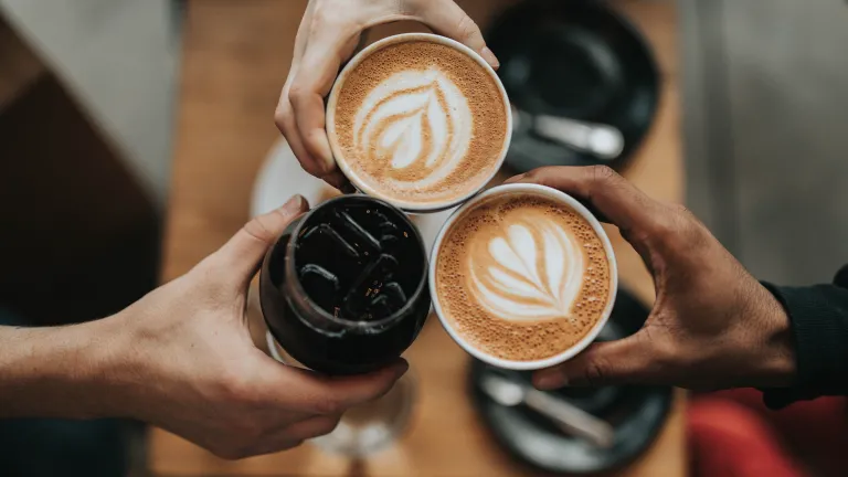 Being hospitable is so much more than offering refreshments like coffee and cake. three hands, each holding a cup of coffee