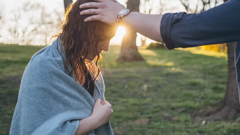 A photo illustration of the laying on of hands after a water baptism.
