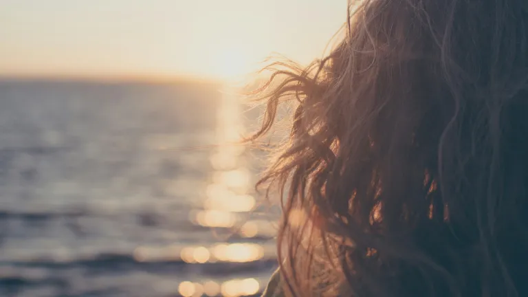 Knowing God is on our side and trusting Him to lead us is the way to achieve a truly positive outlook. A woman looking out on the ocean.
