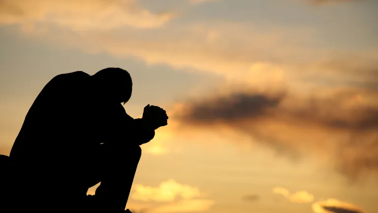 It has been said, “God has two thrones, one in the highest heavens, the other in the lowliest hearts.” A person bent over praying.