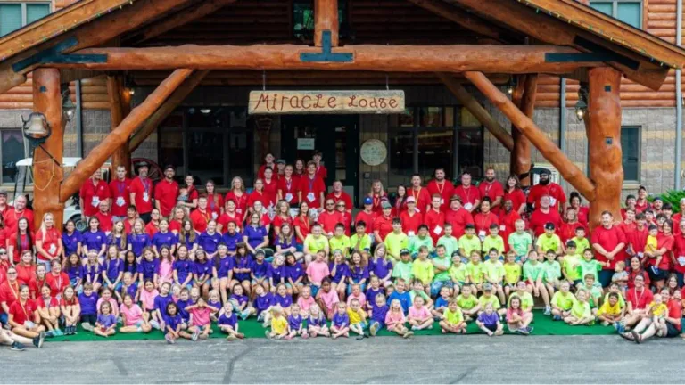 a large group of people, mostly children, with matching shirts standing outside