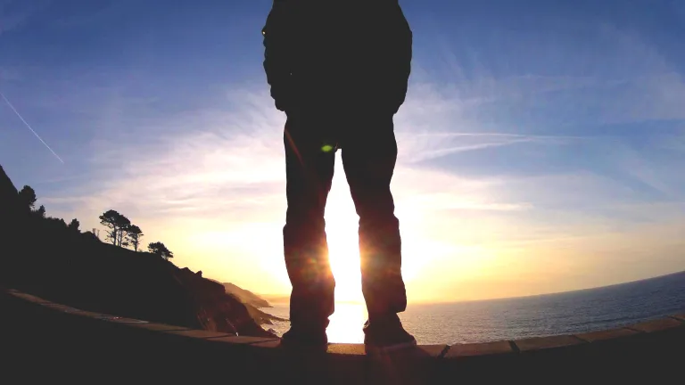 God exists and you can count on that fact. A person standing with the sun's rays shining.