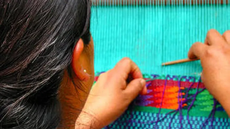 A woman weaving on a loom.