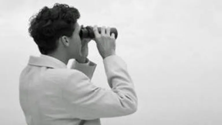 A man looking through binoculars.