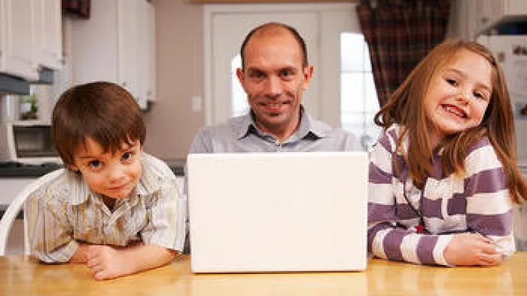 A dad sitting with two kids at a table.