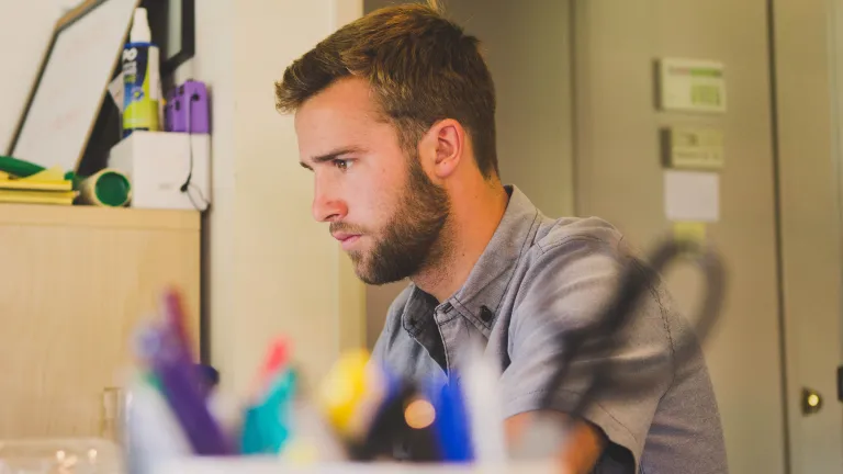 Do you make decisions that lead you closer to fulfilling your dream or making an impact on the world with your talent? A young man working at table.