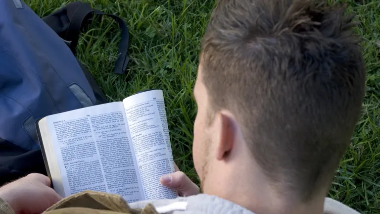 The 12 lesson Bible Study Course will help in understanding the Bible. A young man reading the Bible.